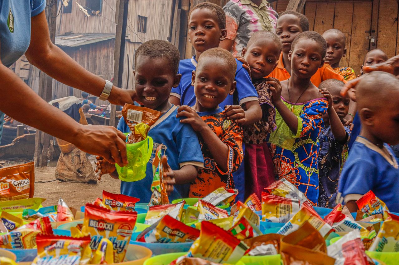 The Art of Drawing Readers In: Your attractive post title goes here Joyful children receiving food supplies from a volunteer in an outdoor setting.